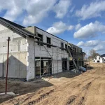 Budowa nowoczesnych domów na sprzedaż w Głogowie – inwestycja mieszkaniowa w trakcie ocieplania i prac elewacyjnych.