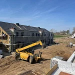 Budowa nowoczesnych domów na sprzedaż w Głogowie – inwestycja mieszkaniowa na etapie prac elewacyjnych i wykańczania dachów.