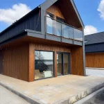 Nowoczesny dom z drewnianą elewacją i balkonem – przykład estetycznego budownictwa mieszkaniowego